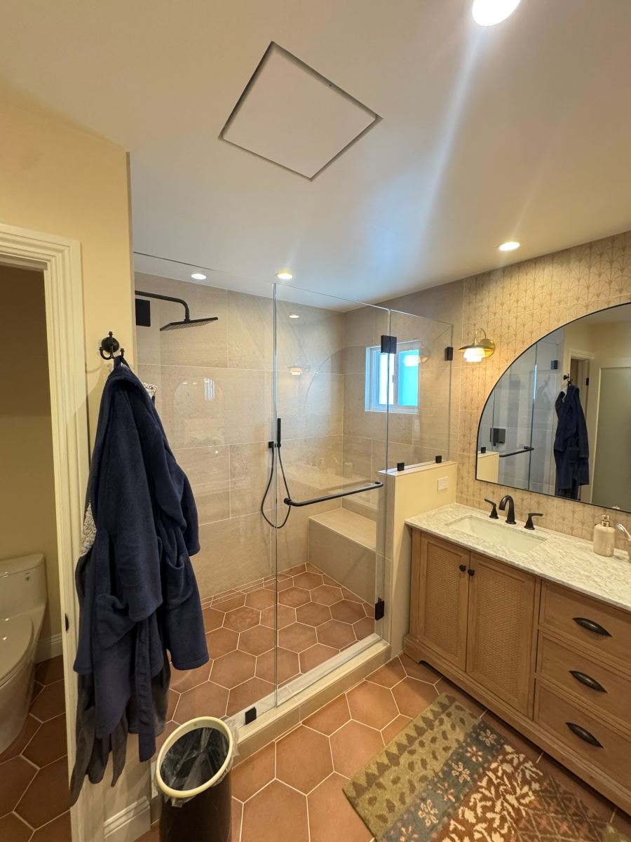Bathroom remodel with hex tile floor, walk-in shower and wood vanity