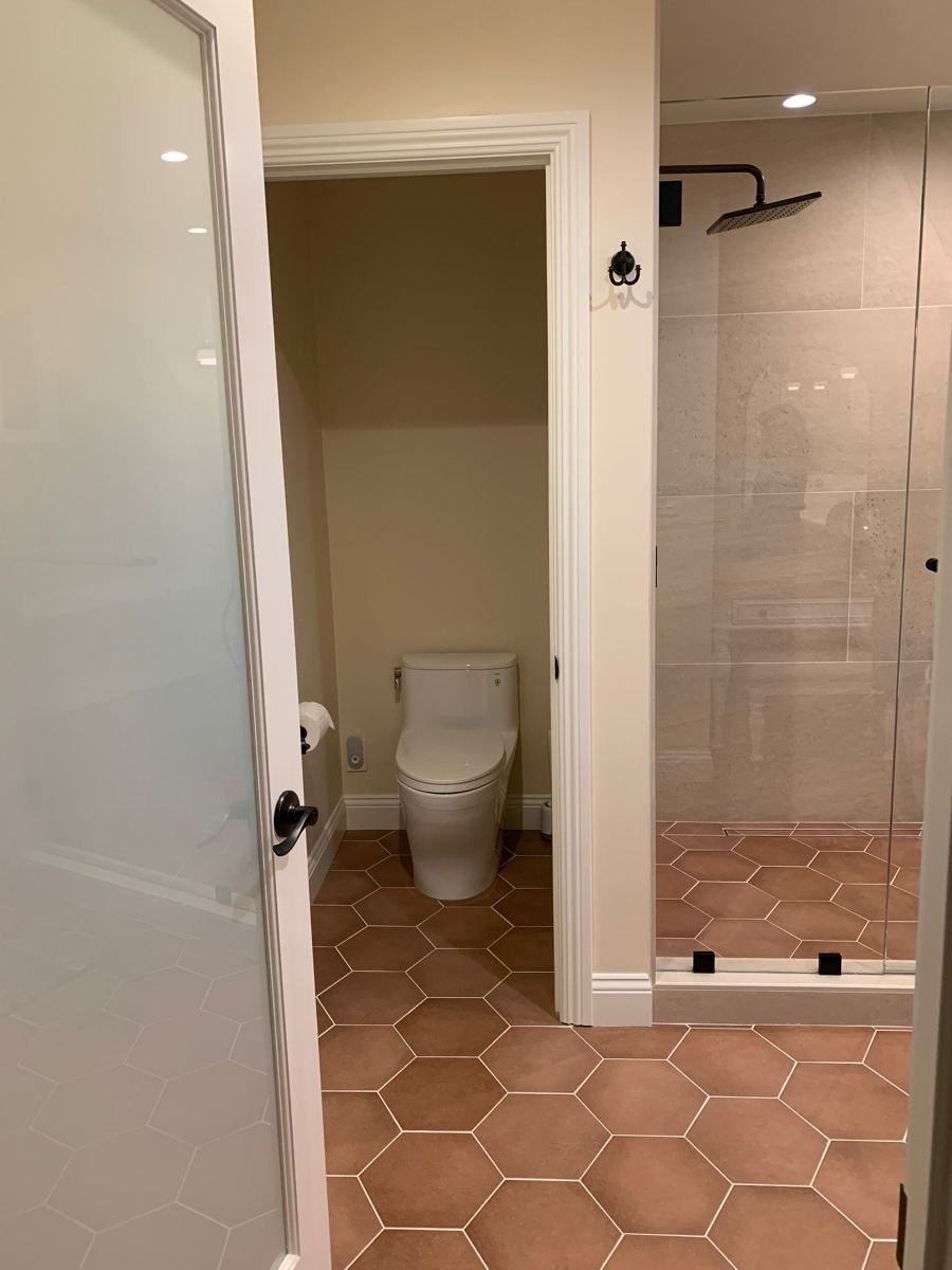 Remodeled bathroom with private toilet room and hex tile floor