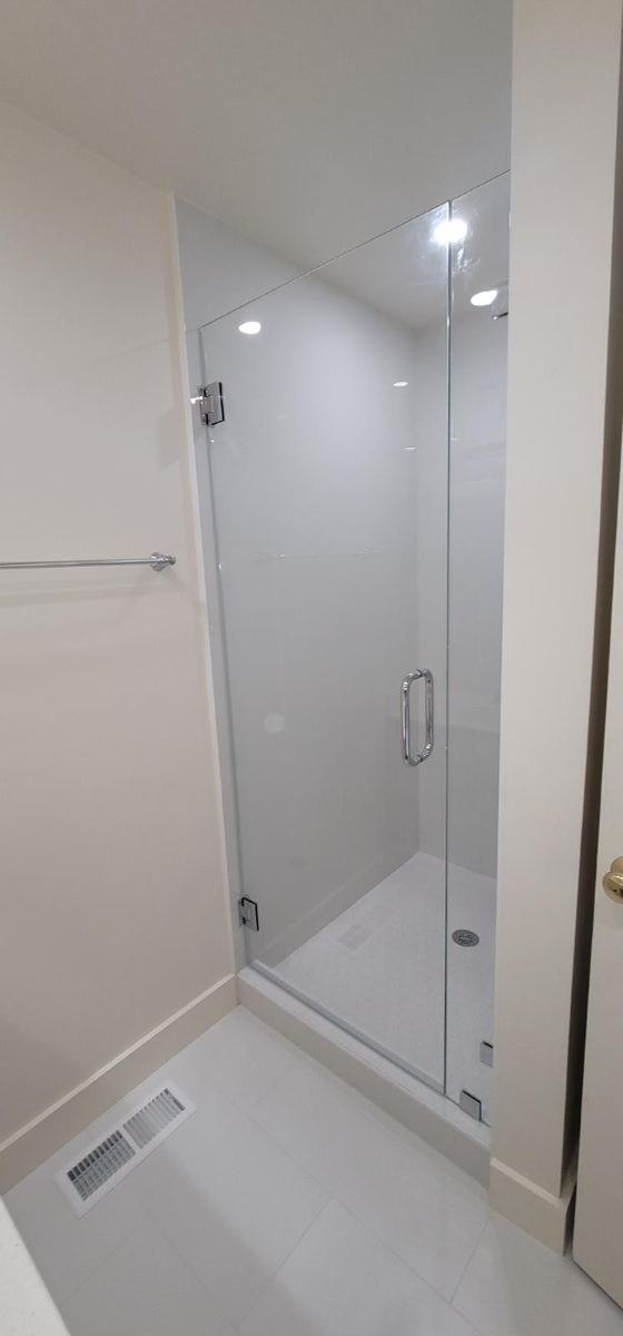 Frameless glass shower in a modern white bathroom